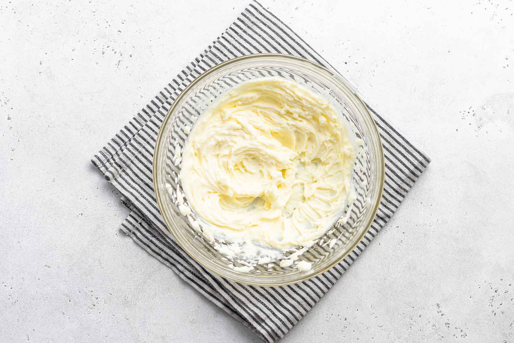 Lemon cream cheese frosting in clear bowl.