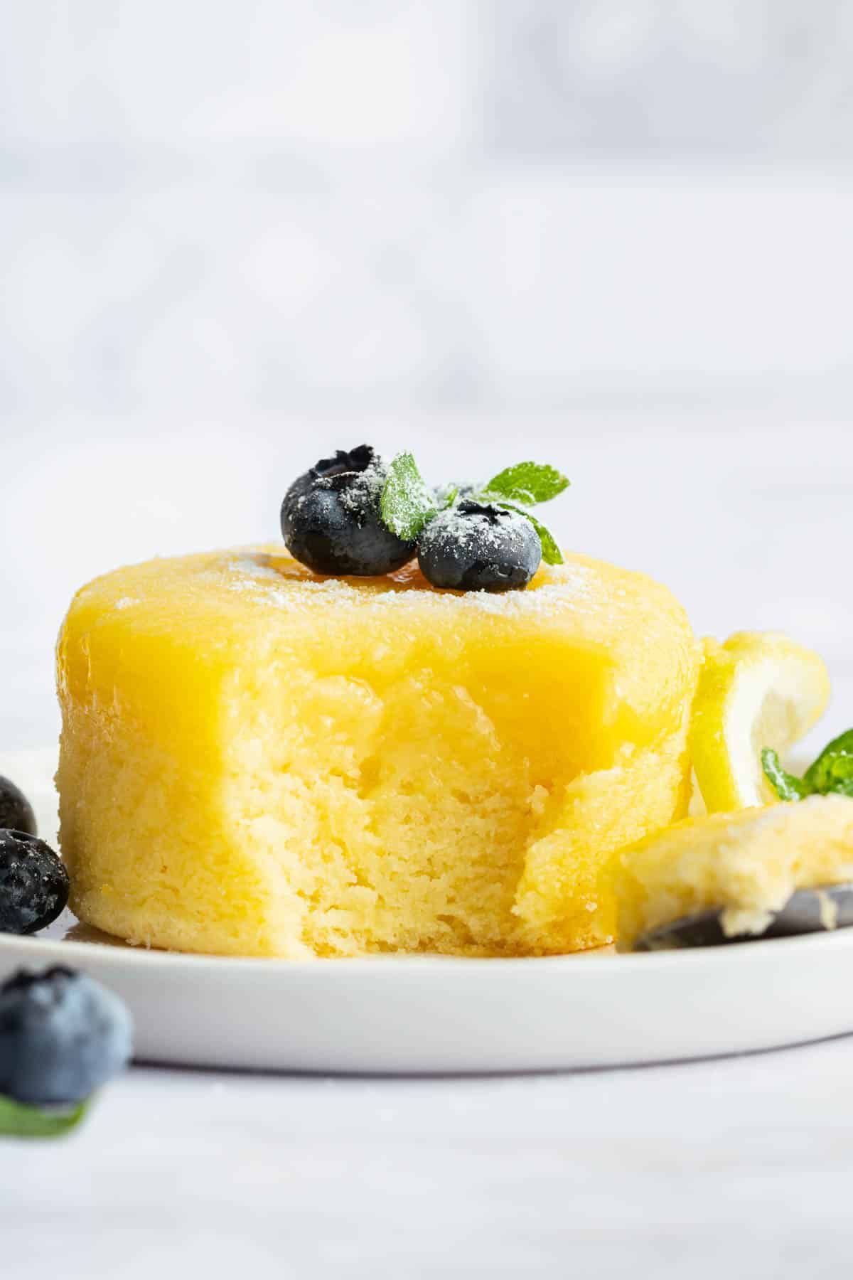 Lemon pudding cake with one bit missing to show insides.