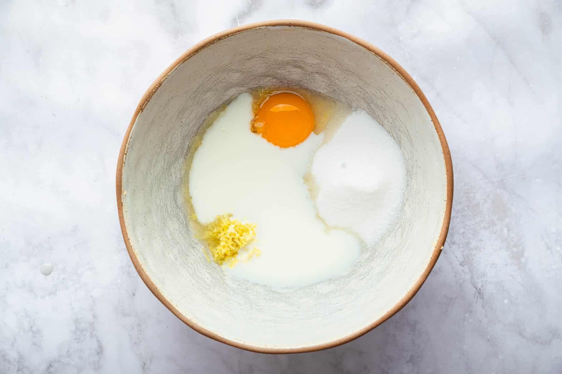 Mixing bow with white liquid and orange egg yolk.