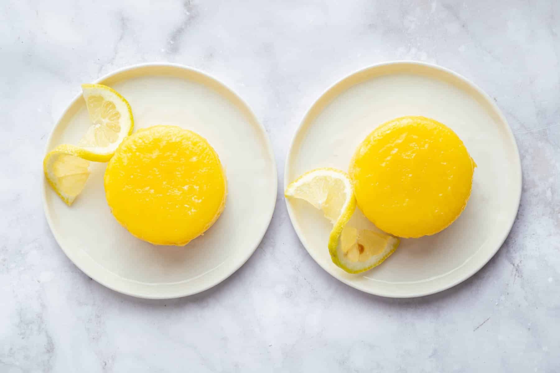 Lemon pudding cakes flipped over onto two serving plates.