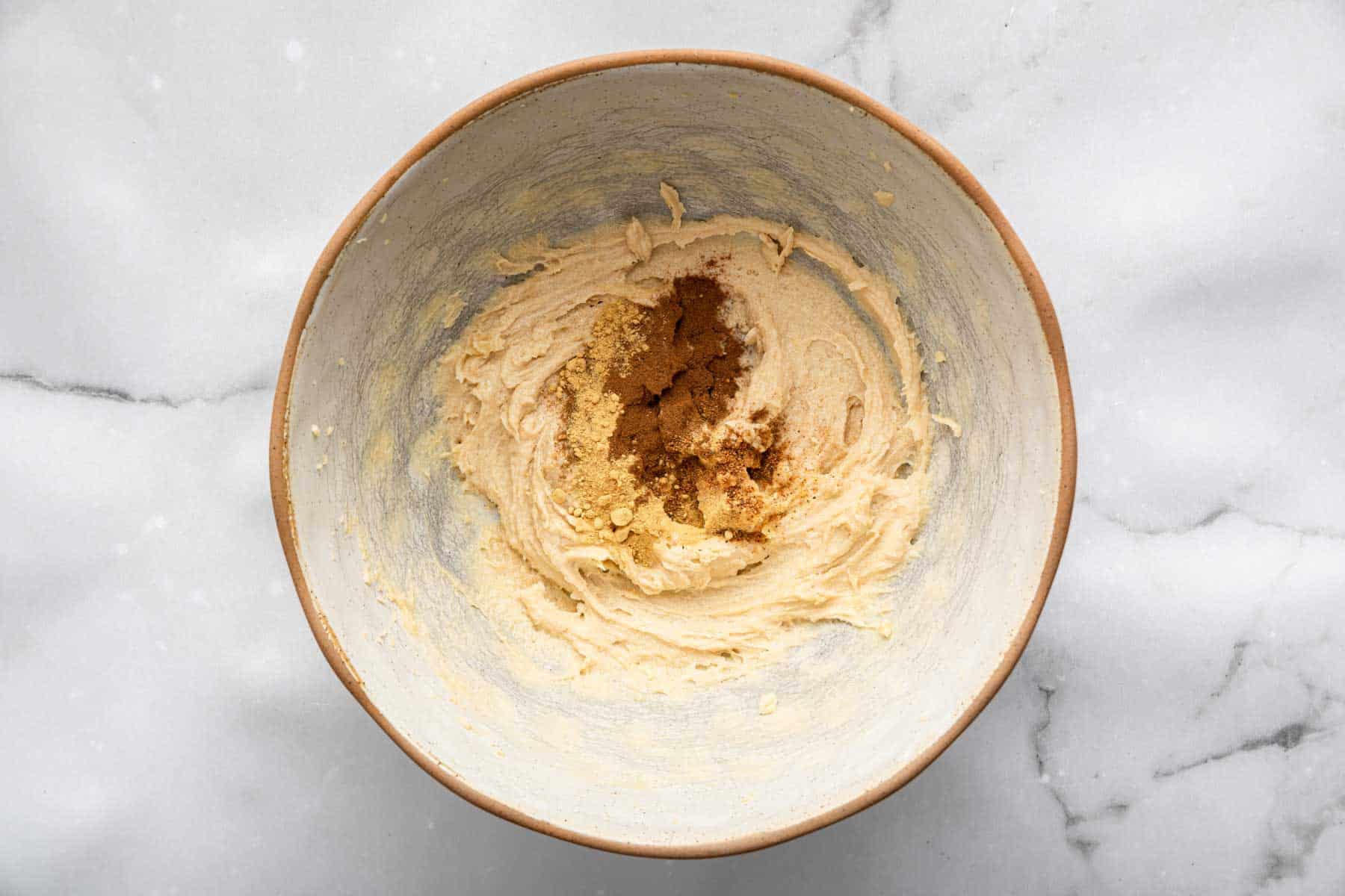 Fluffy butter in a grey pottery bowl with spices on top.