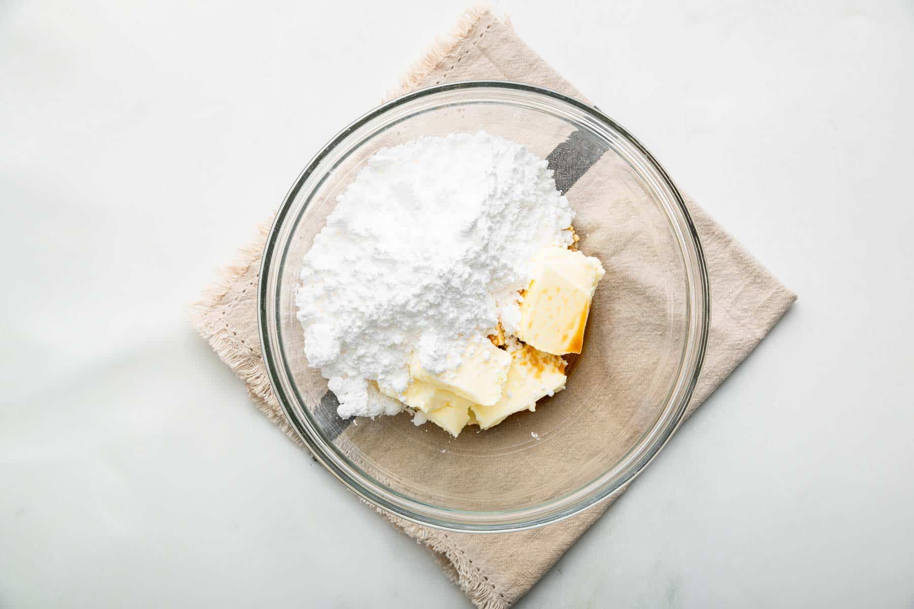 Bowl of softened butter, powdered sugar, and vanilla extract.