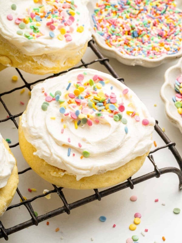 Wire cooling rack with frosted sugar cookies with sprinkles.