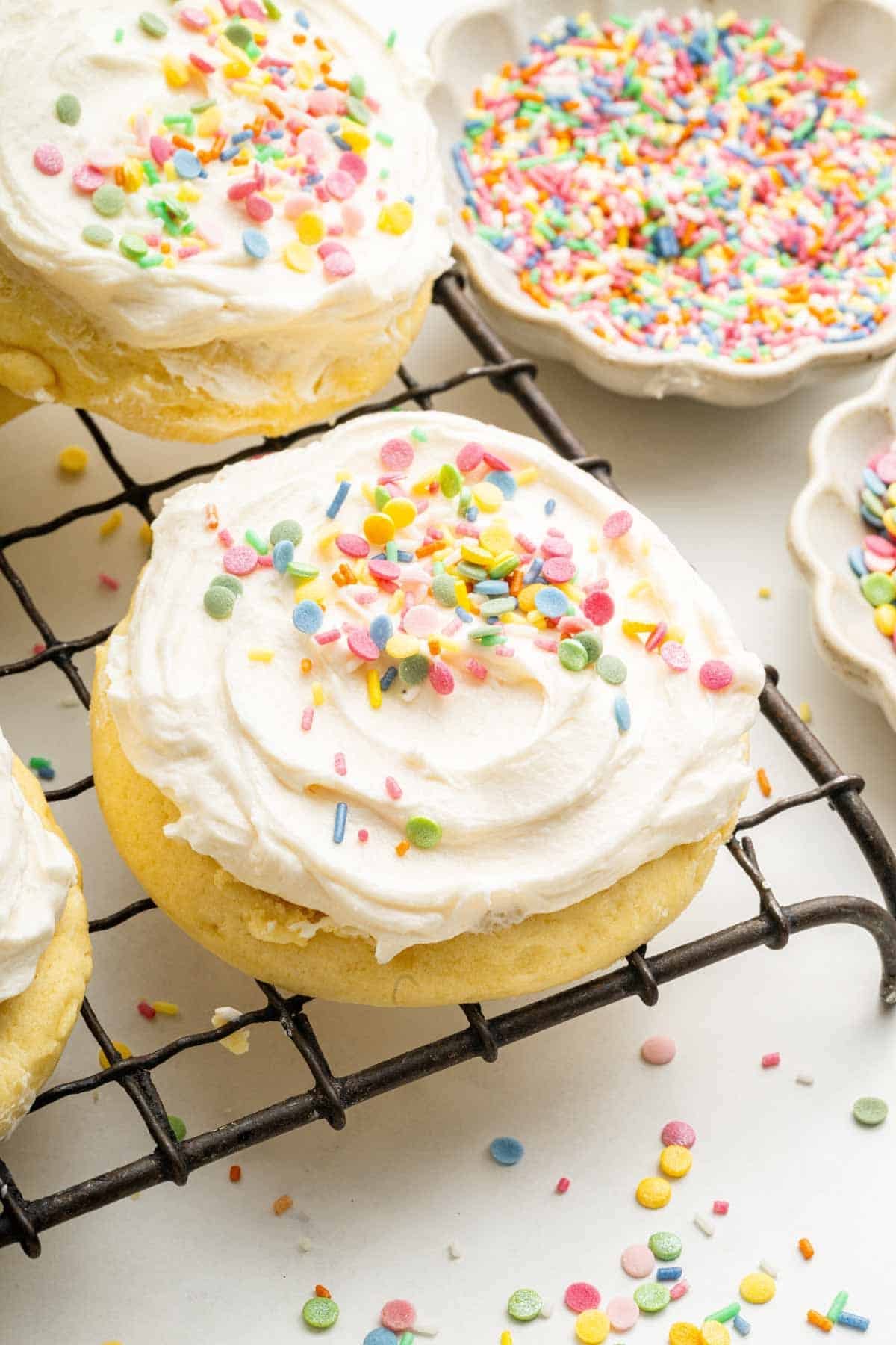 Wire cooling rack with frosted sugar cookies with sprinkles.