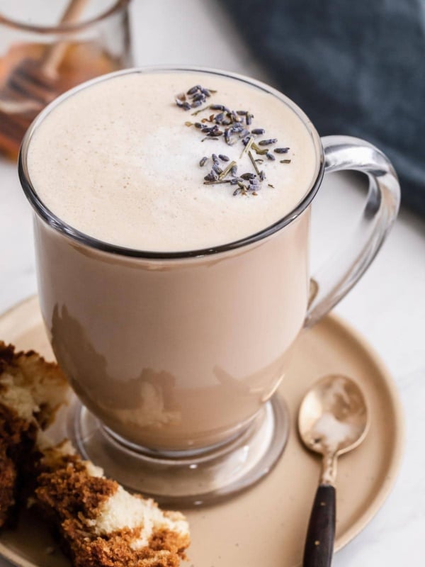 London Fog drink in a clear glass mug with lavender buds on top.