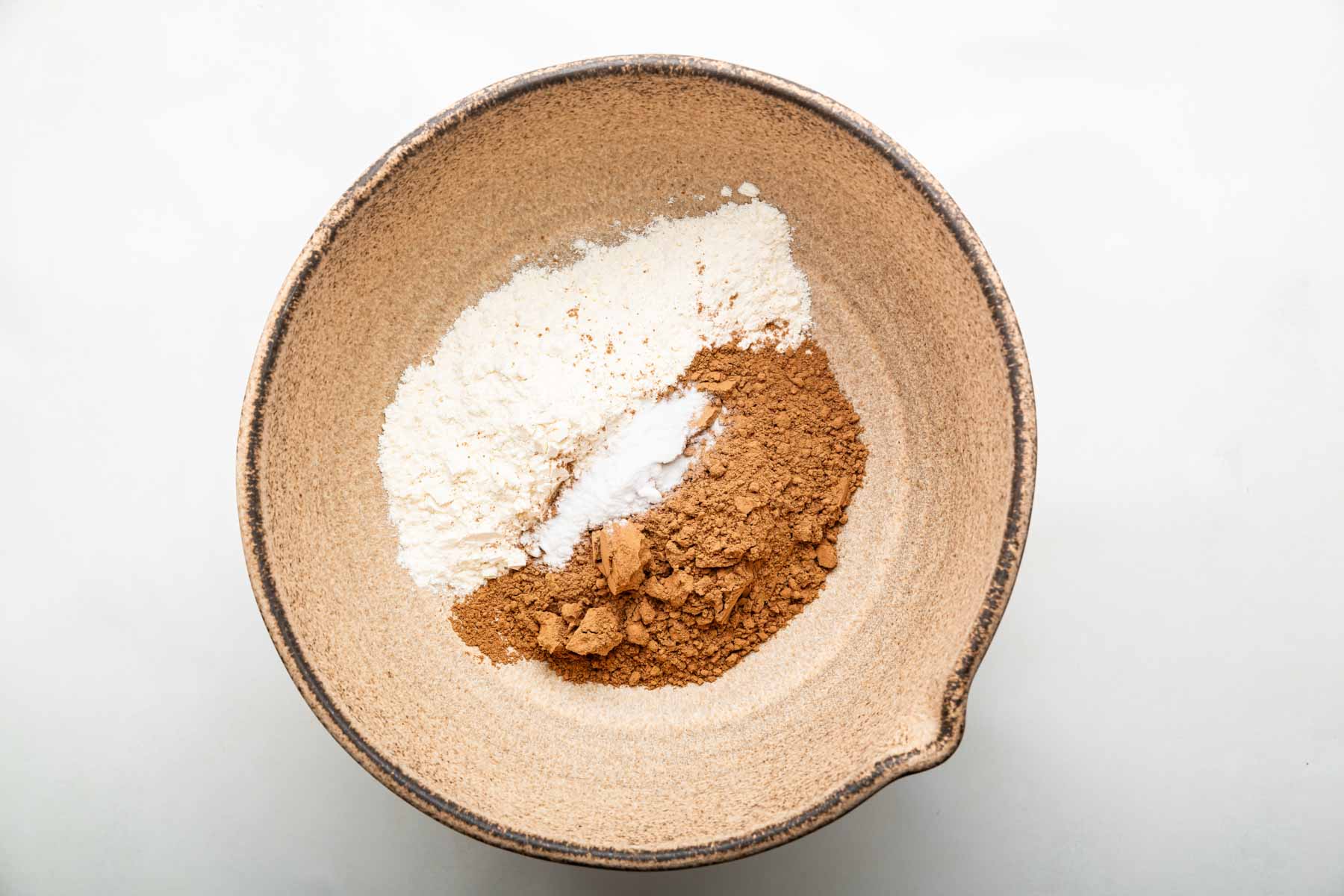 Brown bowl with flour and cocoa powder in it.