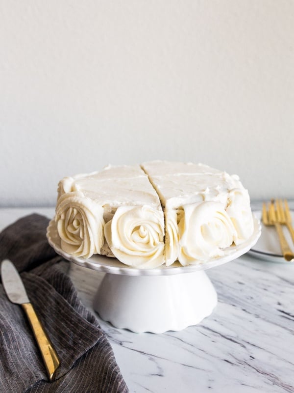 Mini Vanilla Cake for Two people in a 6" small round cake pan. Vanilla buttercream roses on the sides.