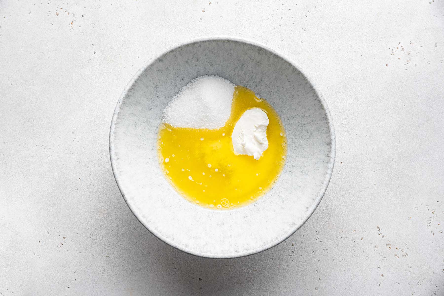 Melted butter, sugar, sour cream and egg white in cake bowl.