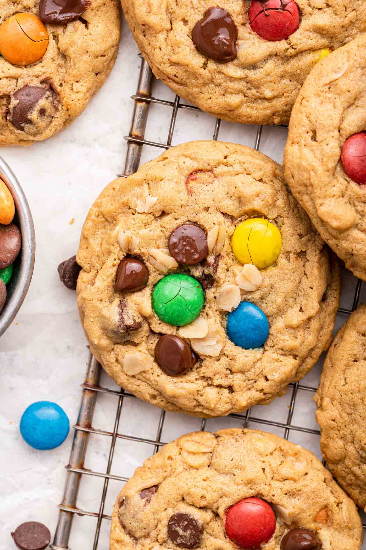 Rainbow monster cookies cooling on a wire rack.