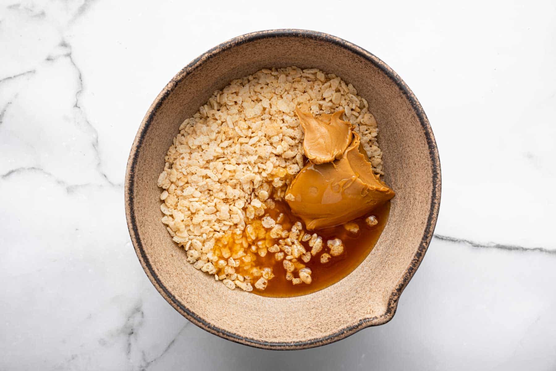Brown bowl with rice cereal and honey and brown batter.
