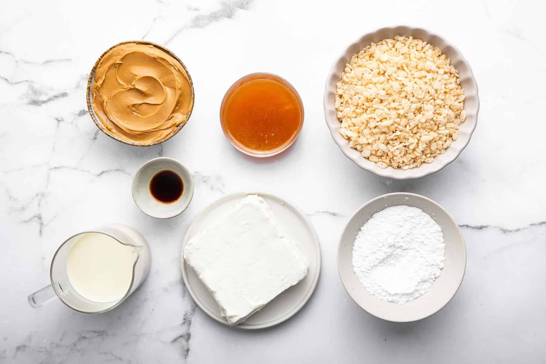 Seven bowls of ingredients on a marble kitchen counter.