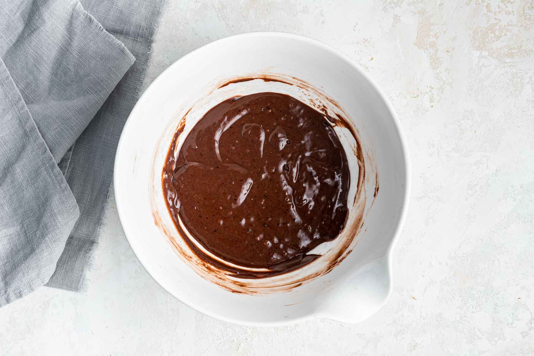 Raw Nutella cupcake batter in white bowl.