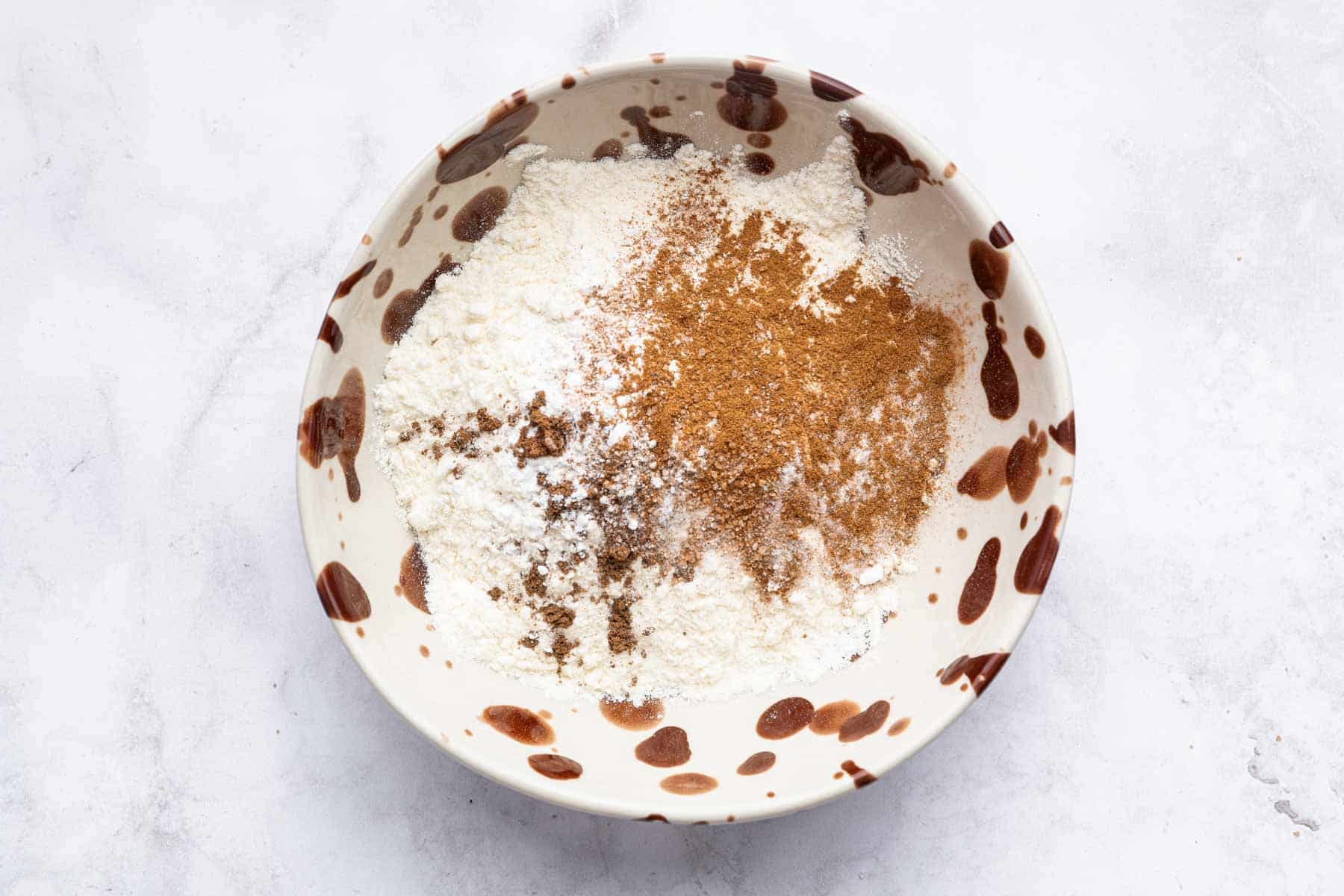 Speckled bowl with flour and spices in it.