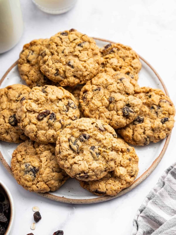 Plate of oatmeal raisin cookies with glass of milk.
