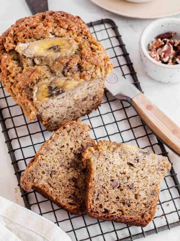 Small loaf of banana bread on wire rack.