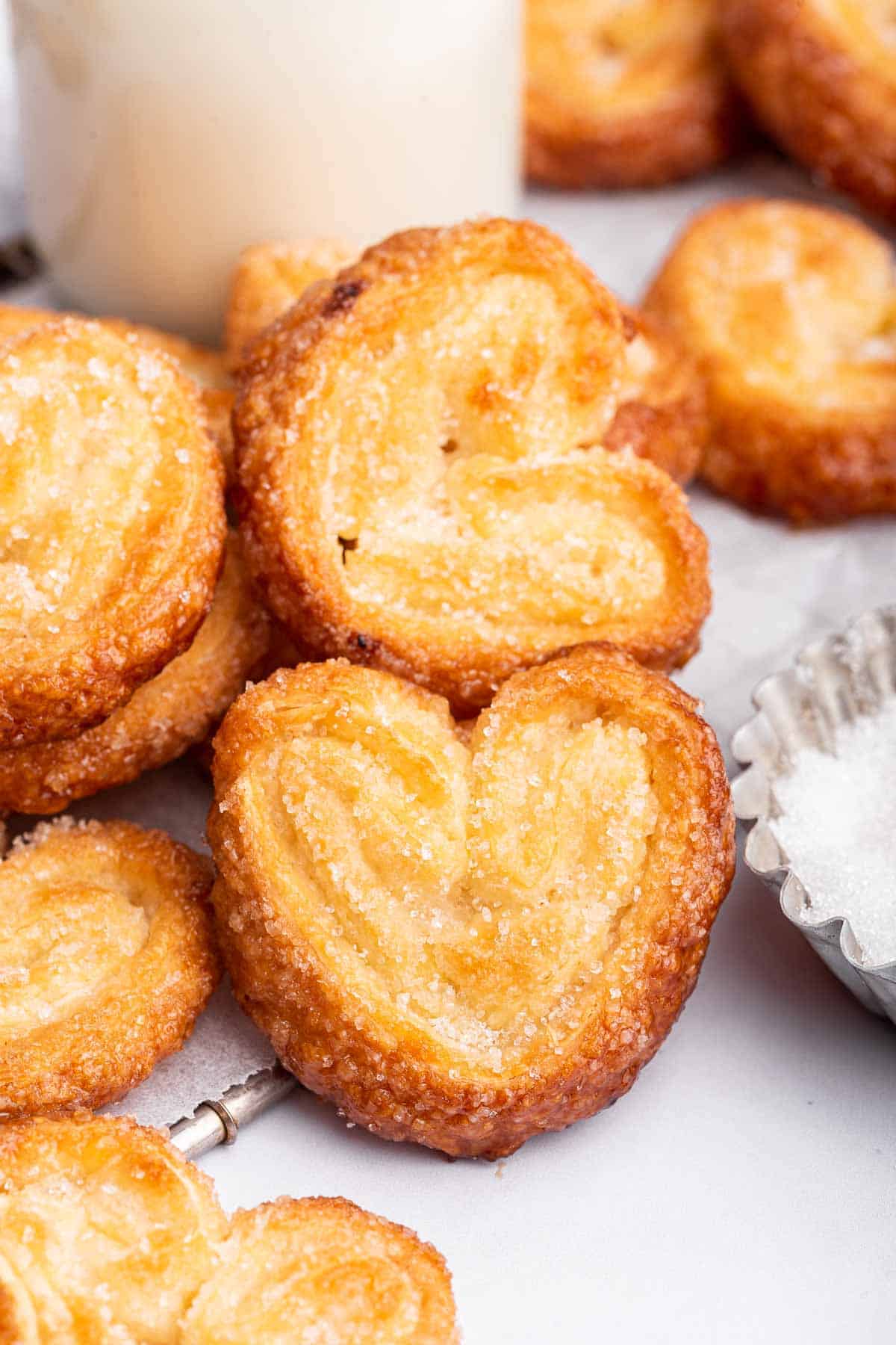Palmiers on table with milk behind them.