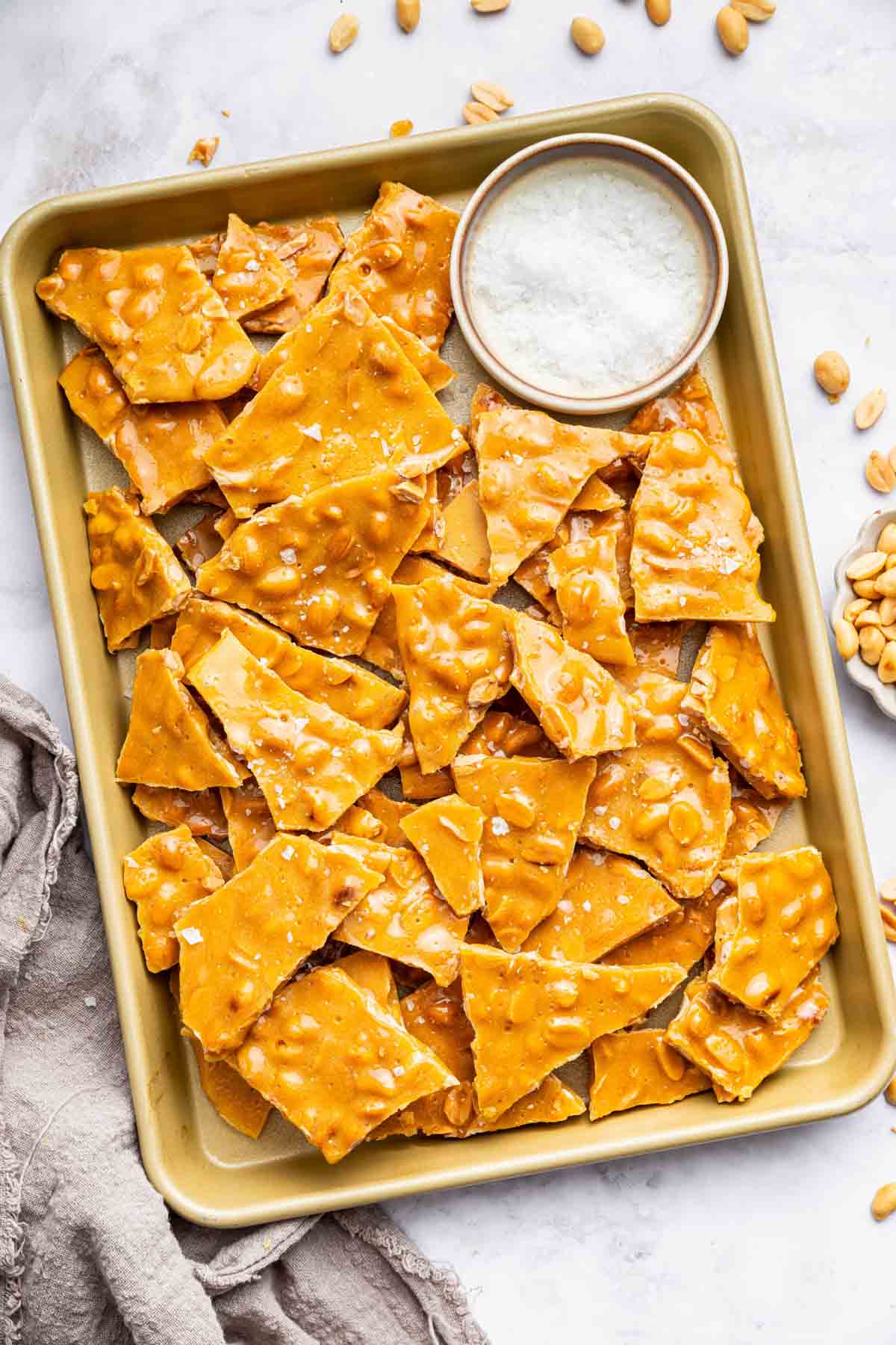 Peanut brittle pieces on a baking sheet.