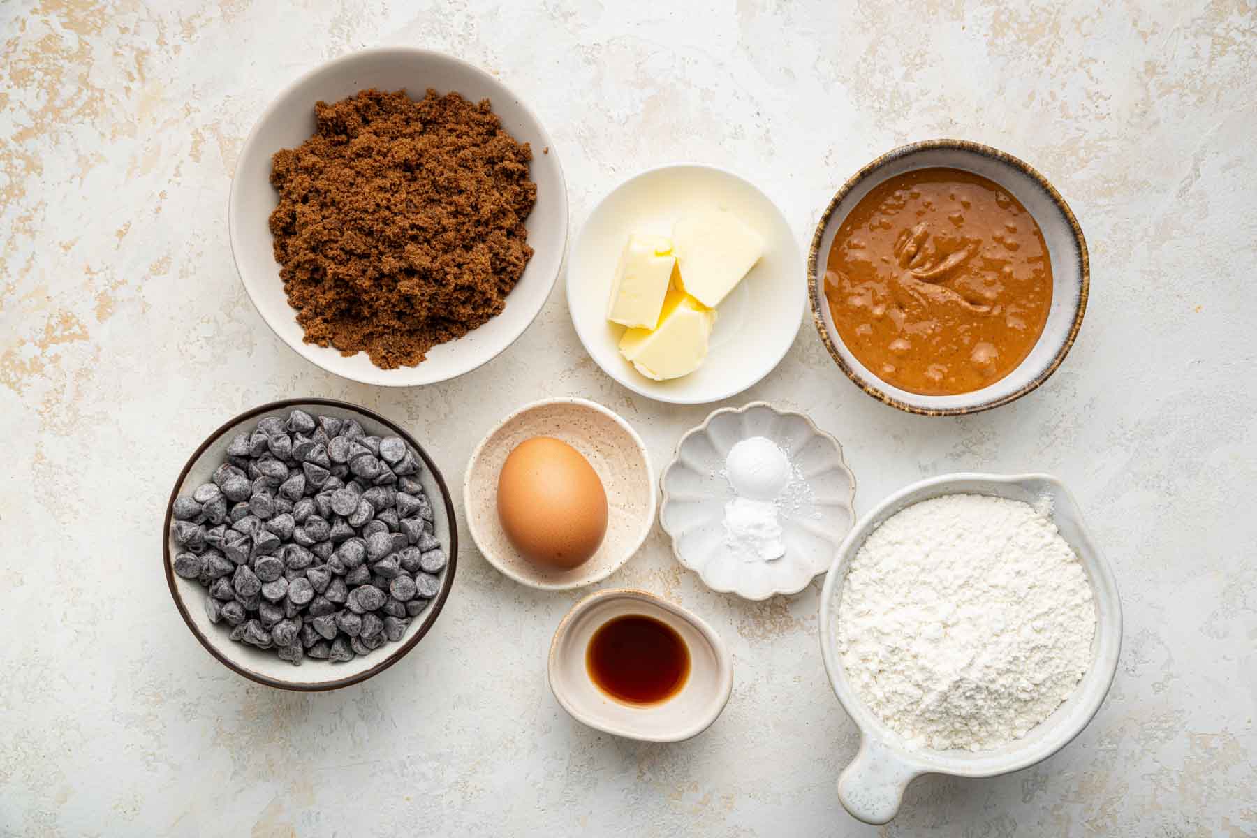 Little bowls of baking supplies on a marble counter.