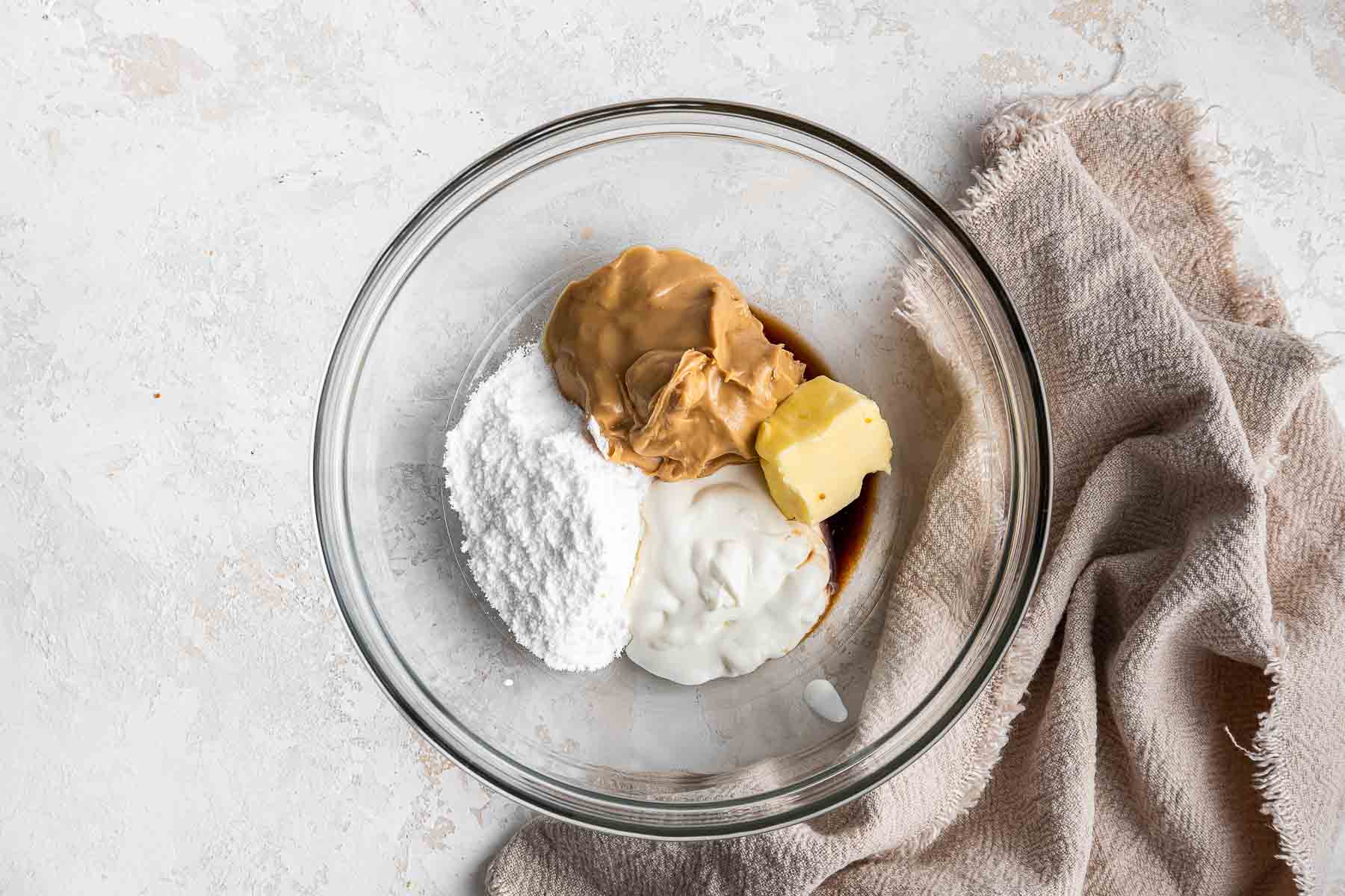 Bowl with peanut butter, sugar, butter and vanilla inside.