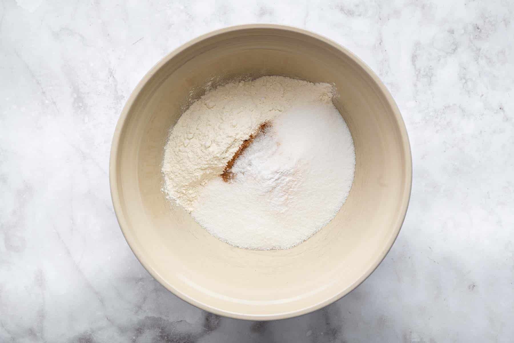 Cream colored bowl with flour, sugar and cinnamon.