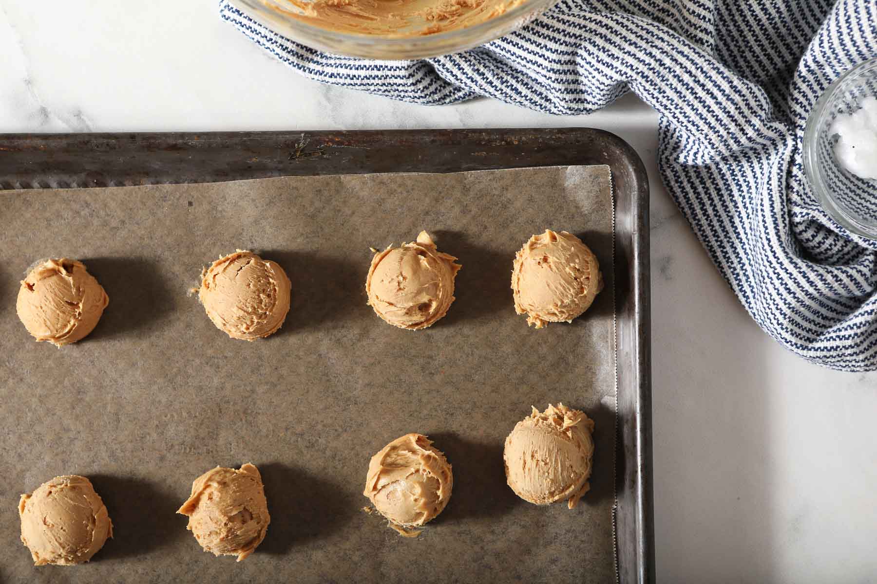 Frozen peanut butter truffles on a baking sheet.
