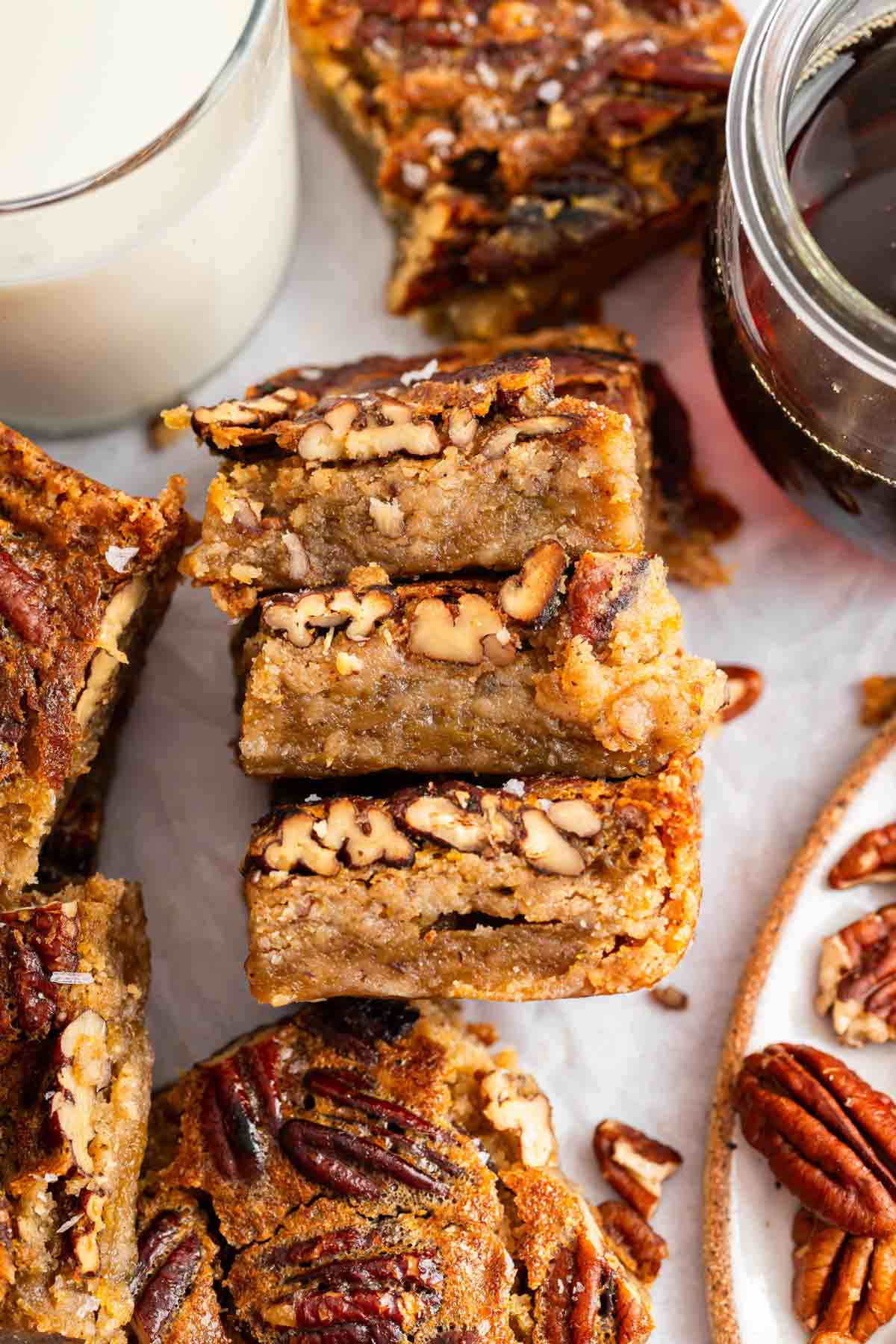 Stack of pecan pie bars showing gooey centers on side.