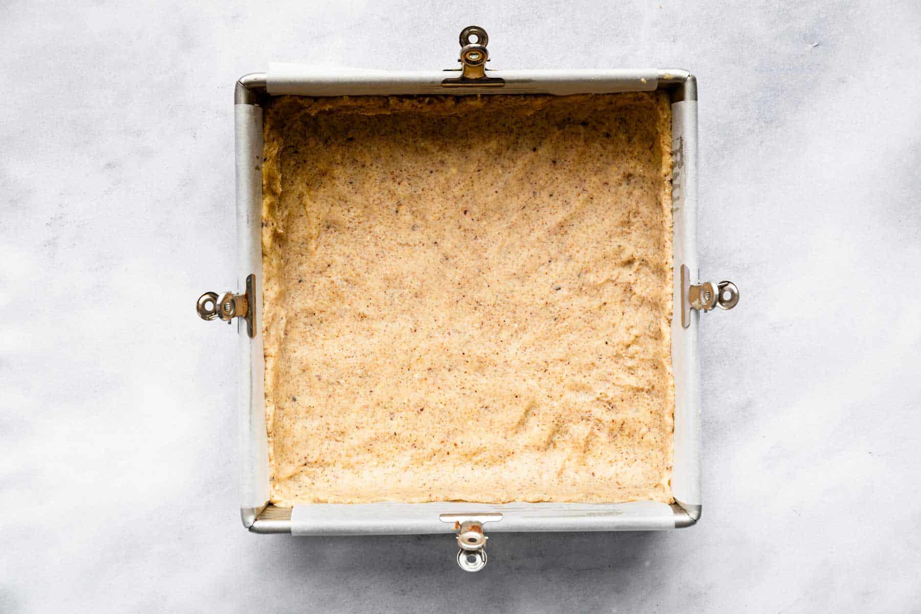 Raw dough pressed into an 8-inch square pan.
