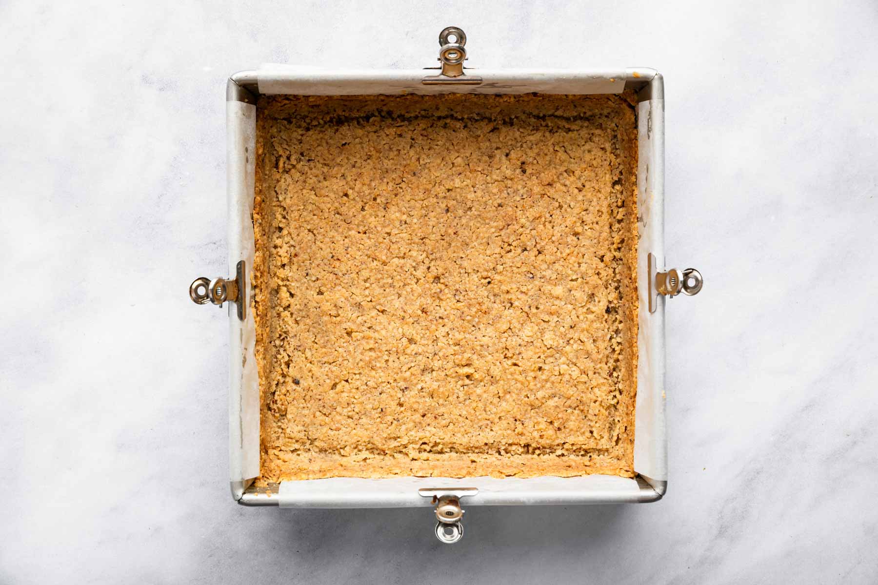 Baked pecan shortbread dough in a square pan.