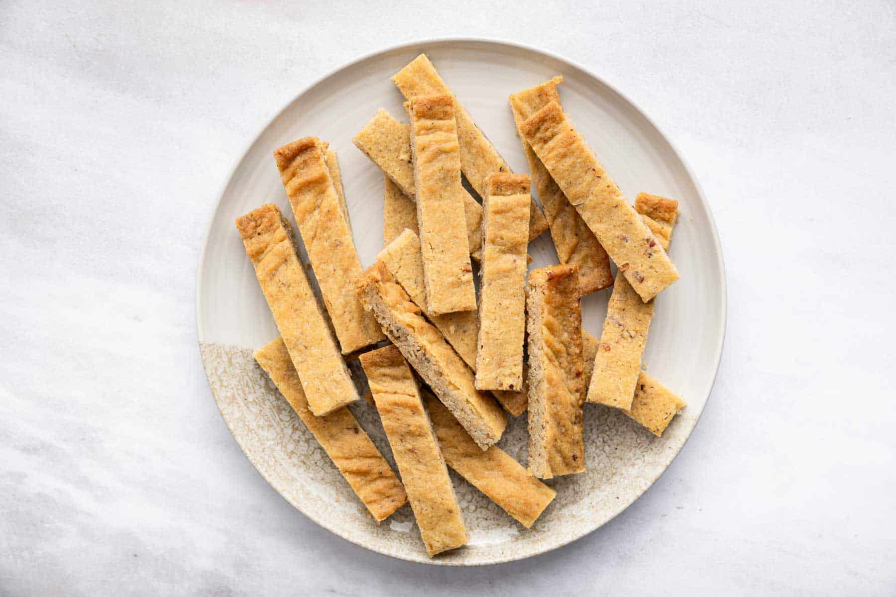 Pecan shortbread sticks on a white plate.
