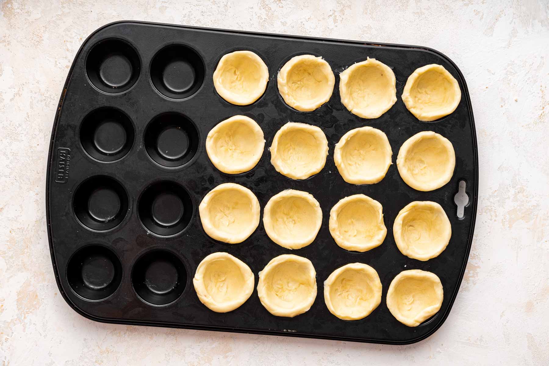 Dough pressed into 16 mini muffin cups.