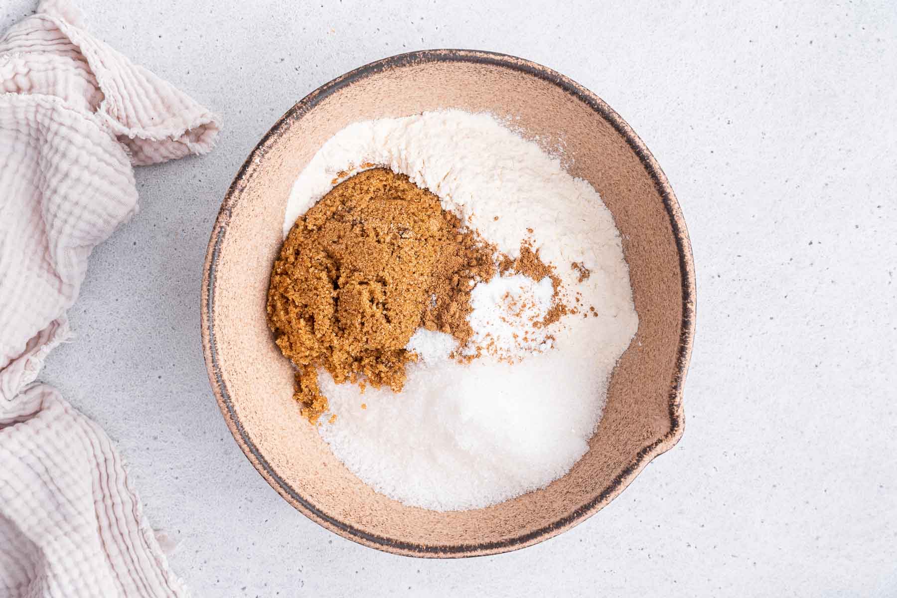 Earthenware bowl with brown sugar, white sugar and flour inside.