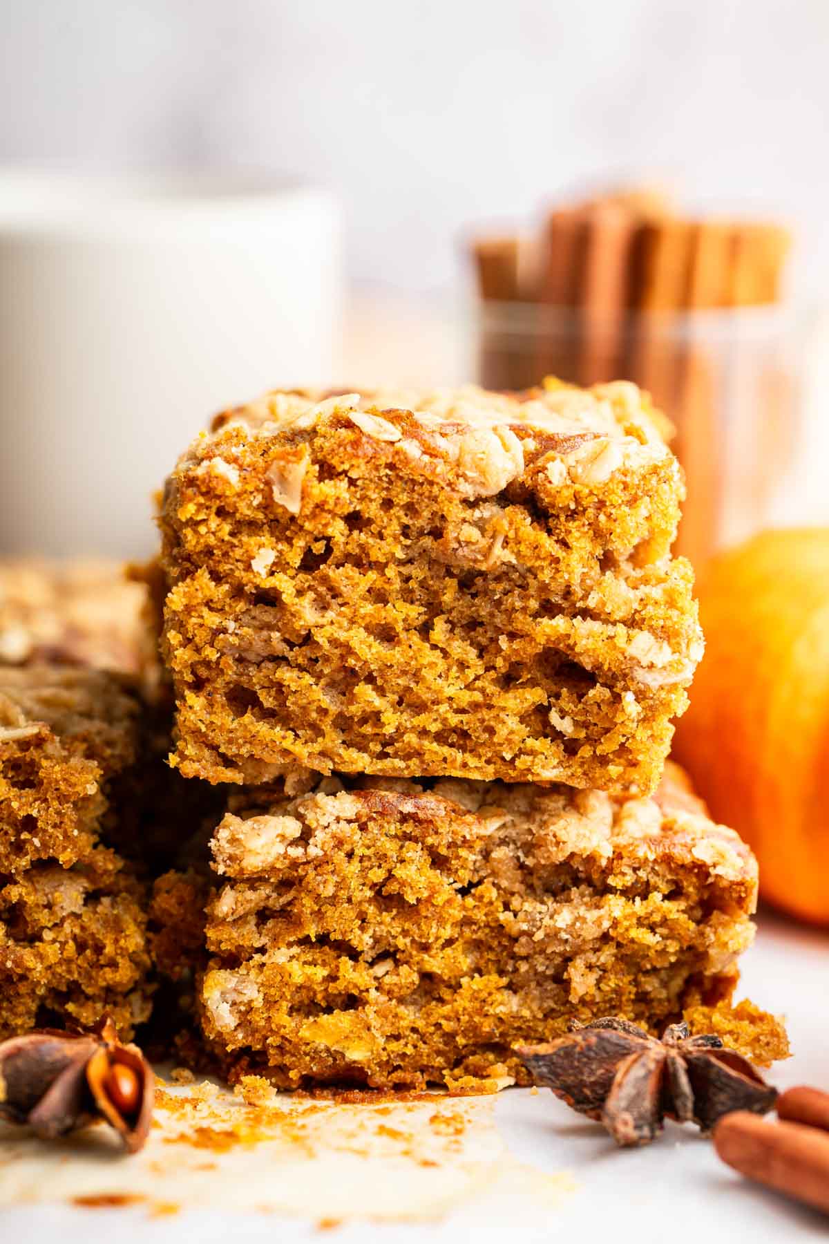 Two square slices of orange pumpkin cake stacked on top of each other.