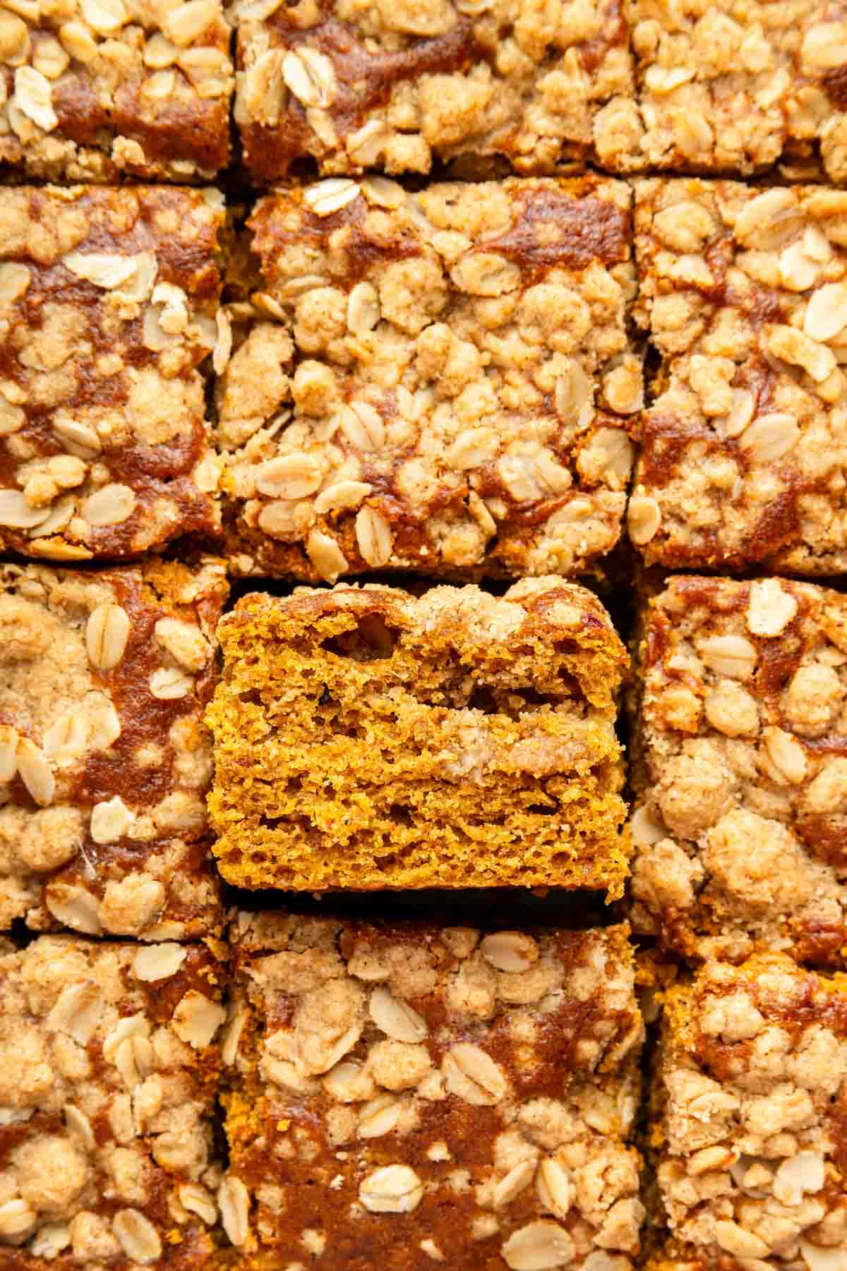 Macro image of pumpkin cake with one slice turned up to show inside crumb.