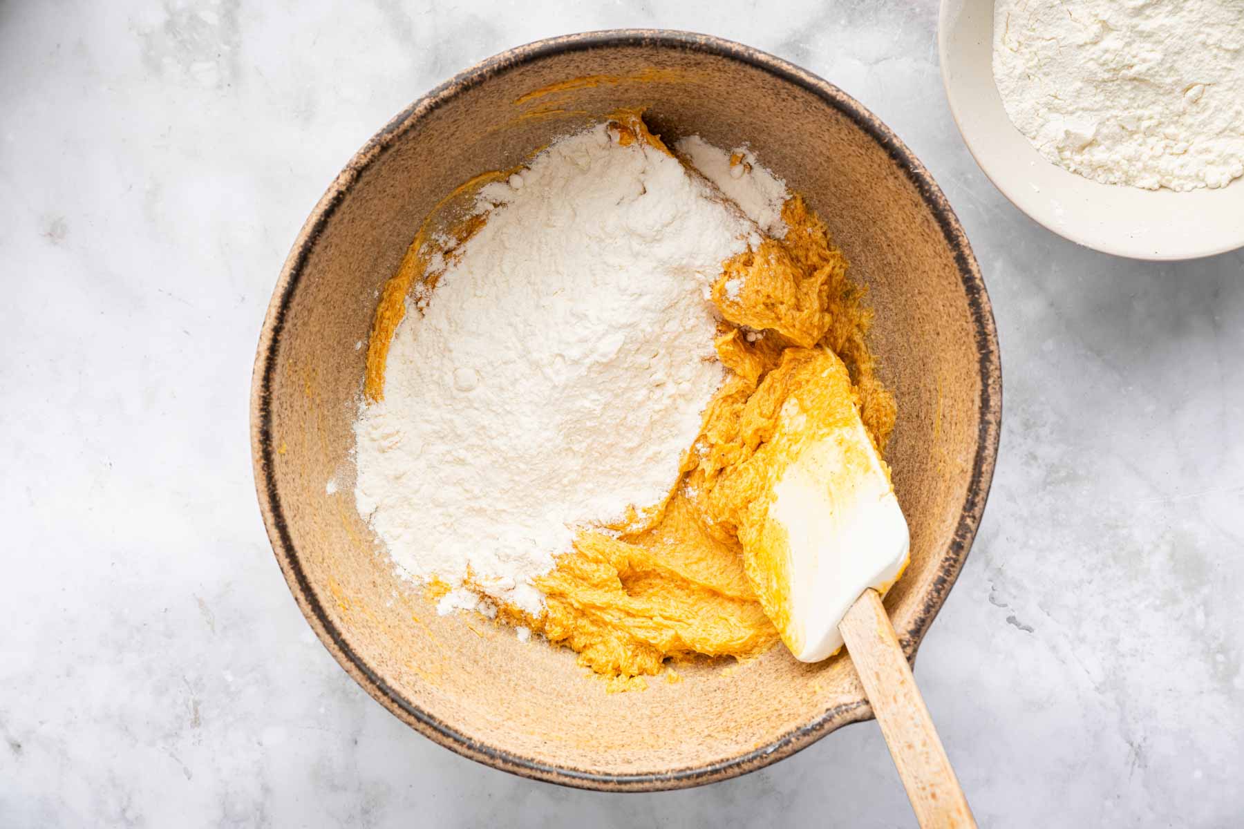 Orange batter with flour on top.