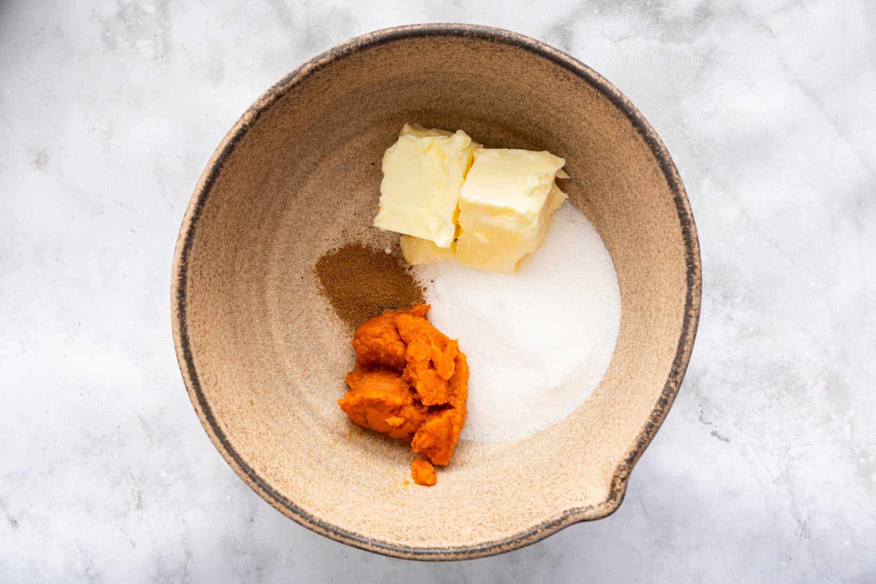 Tan bowl with super soft butter, pumpkin, sugar and spices.