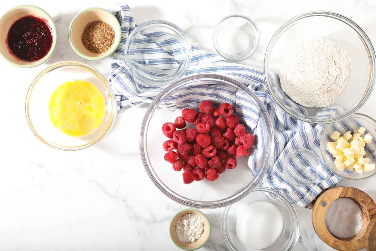 Ingredients for raspberry galette on a marble table.