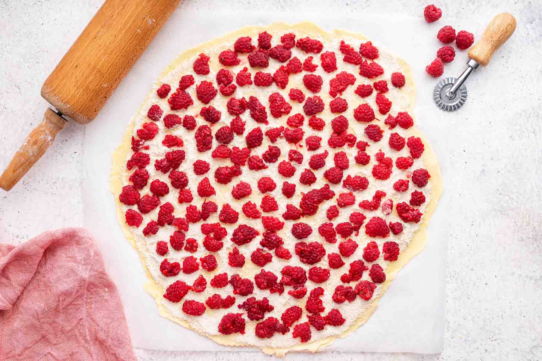 Fresh raspberries spread over a round crust.