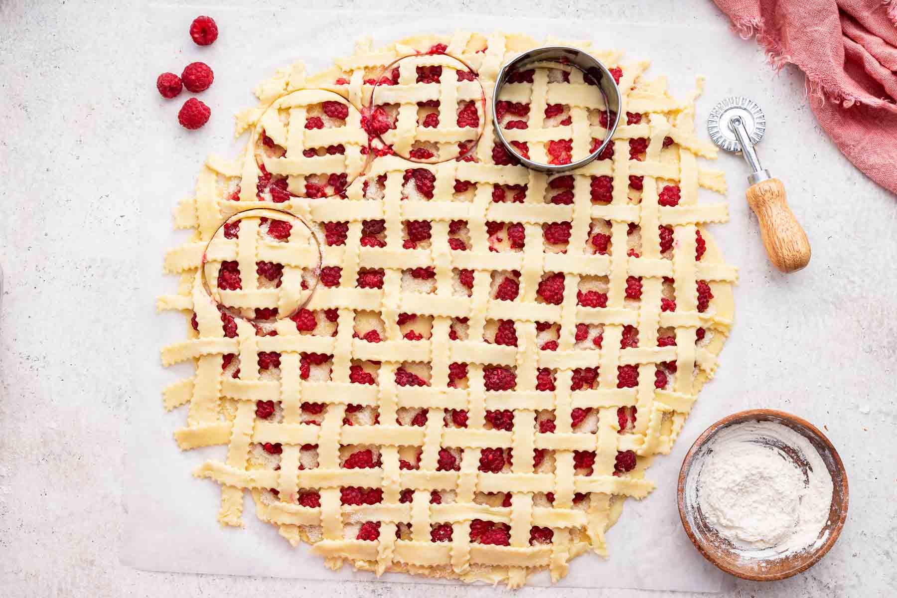Using a circle cutter to cut out lattice cookies.