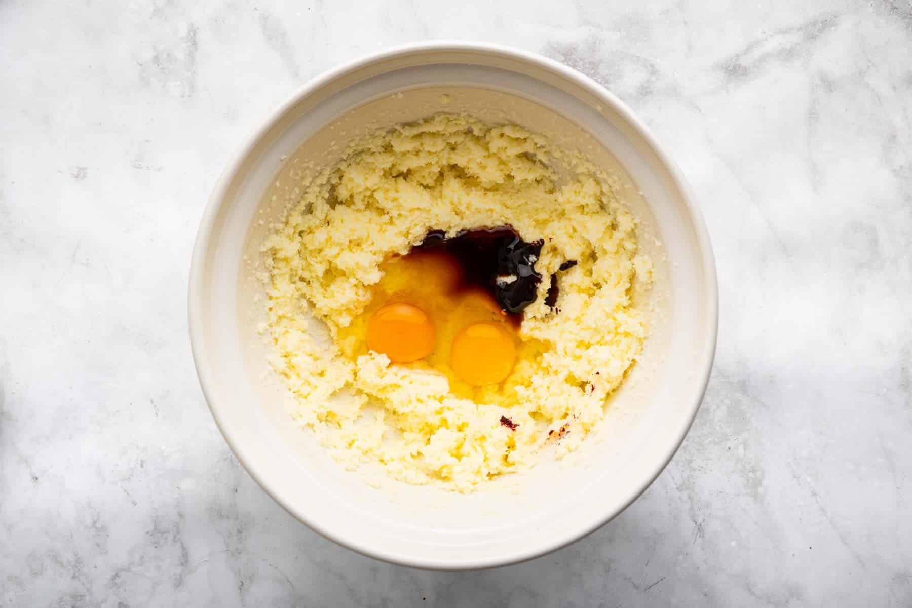 Yellow batter with two egg yolks and a splash of red food gel on top.