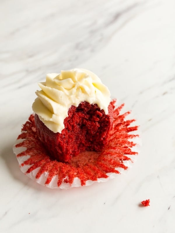 Single red velvet cupcake on a marble table.