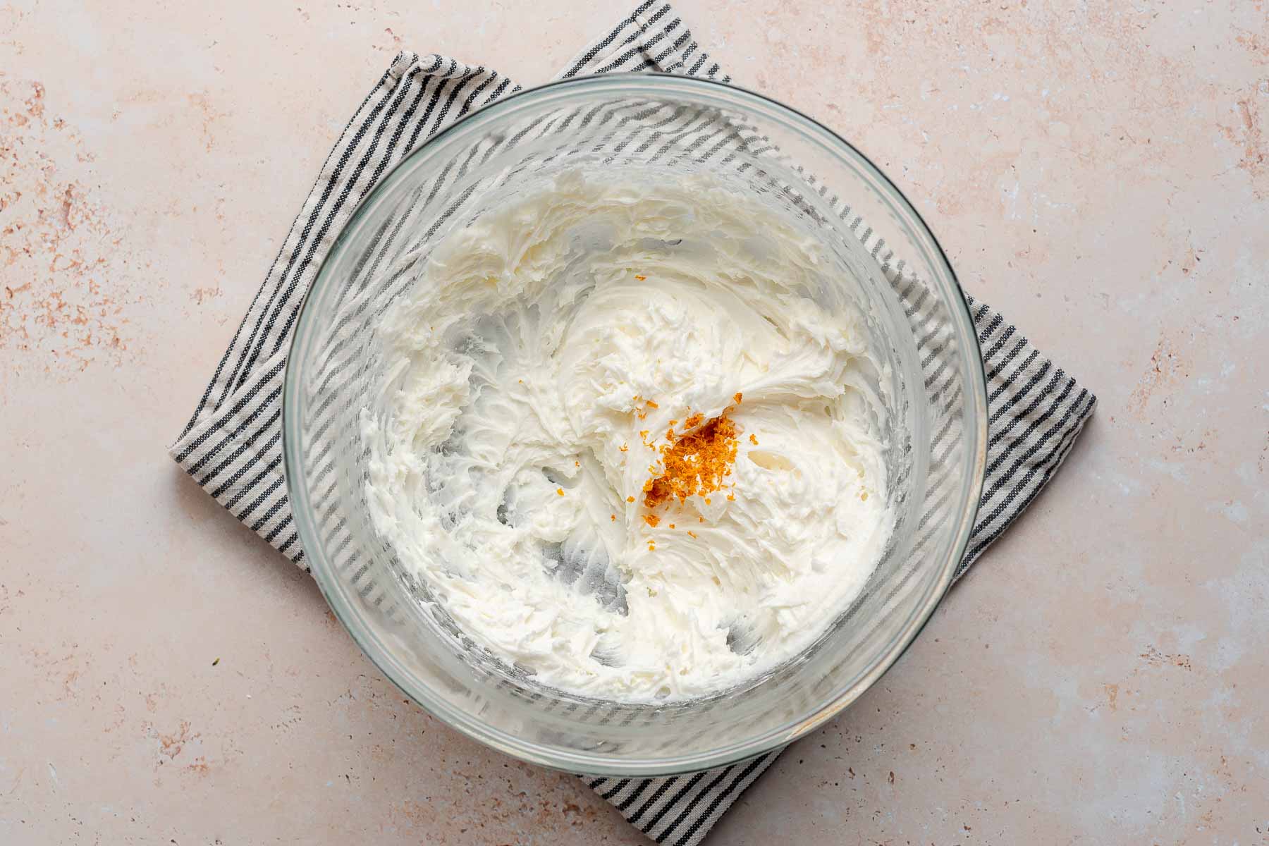 Orange zest in frosting bowl.