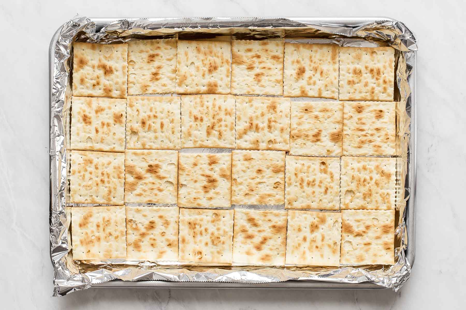 Crackers on a sheet pan lined with foil.