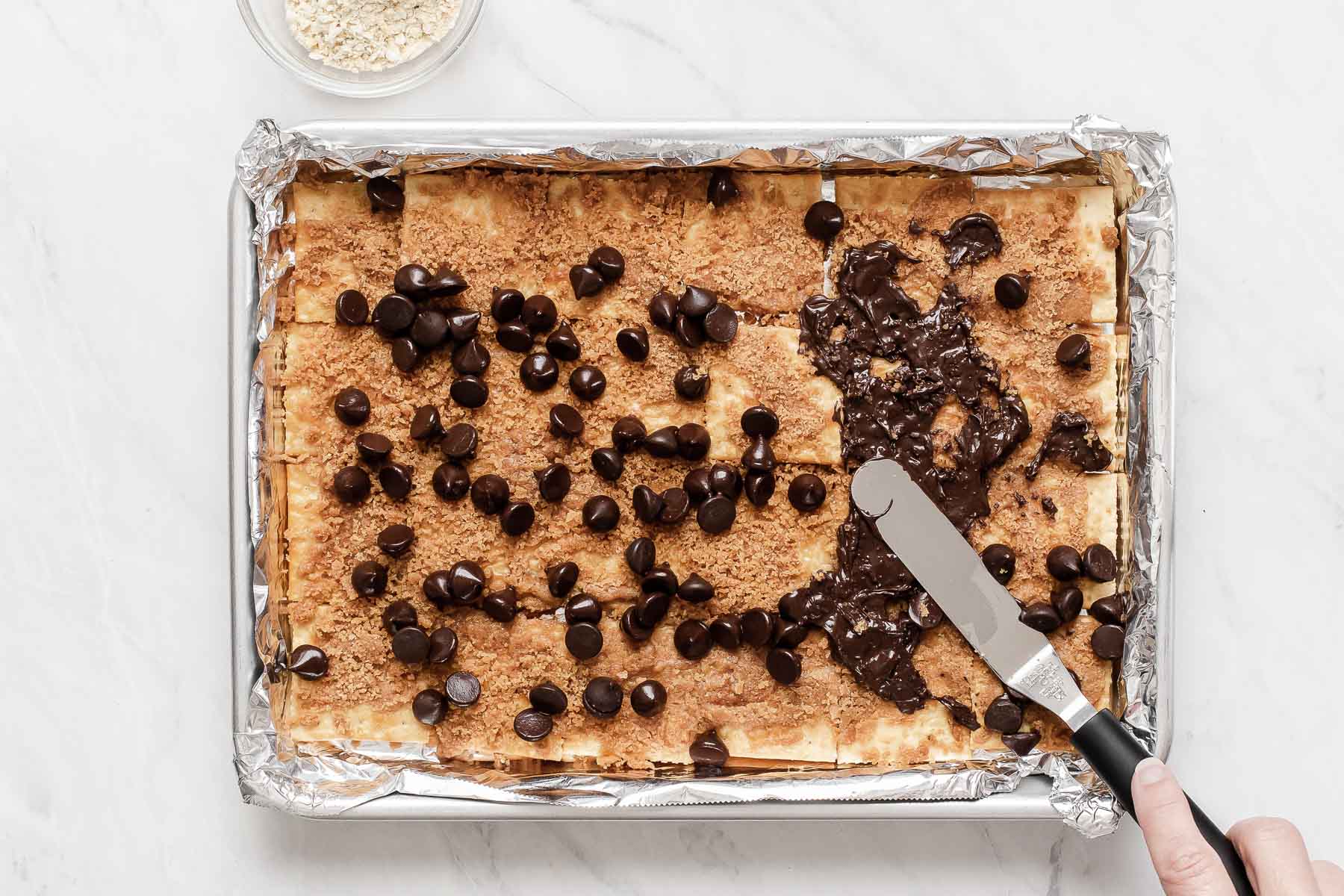 Chocolate chips sprinkled on toffee and crackers.