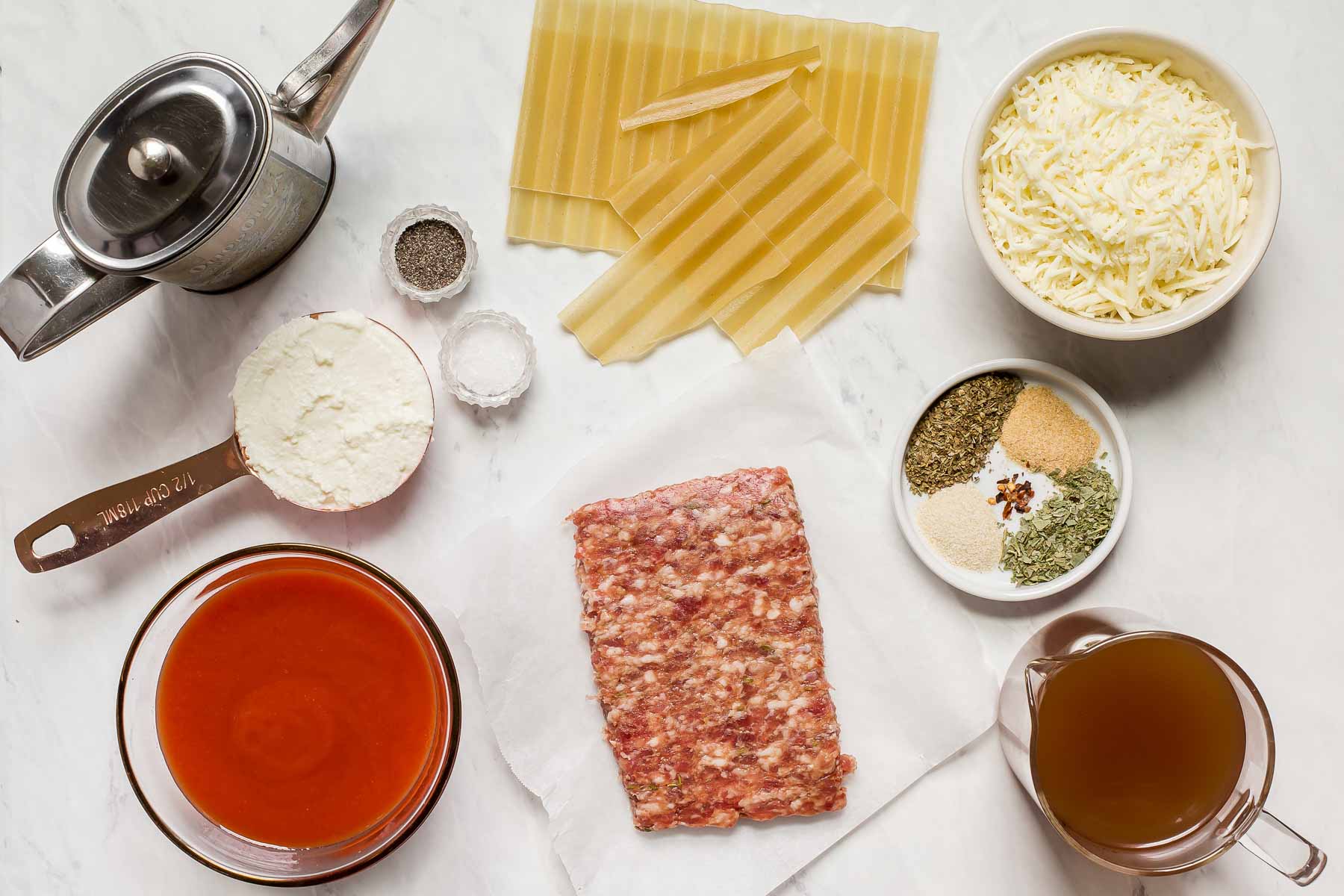 Ingredients for skillet lasagna on white table.