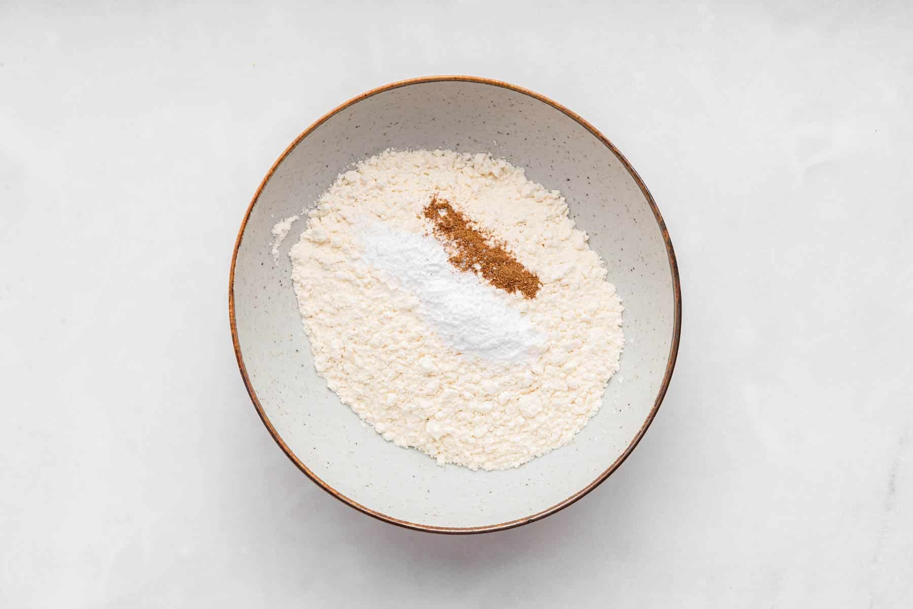 Bowl with flour, sugar and nutmeg in it.