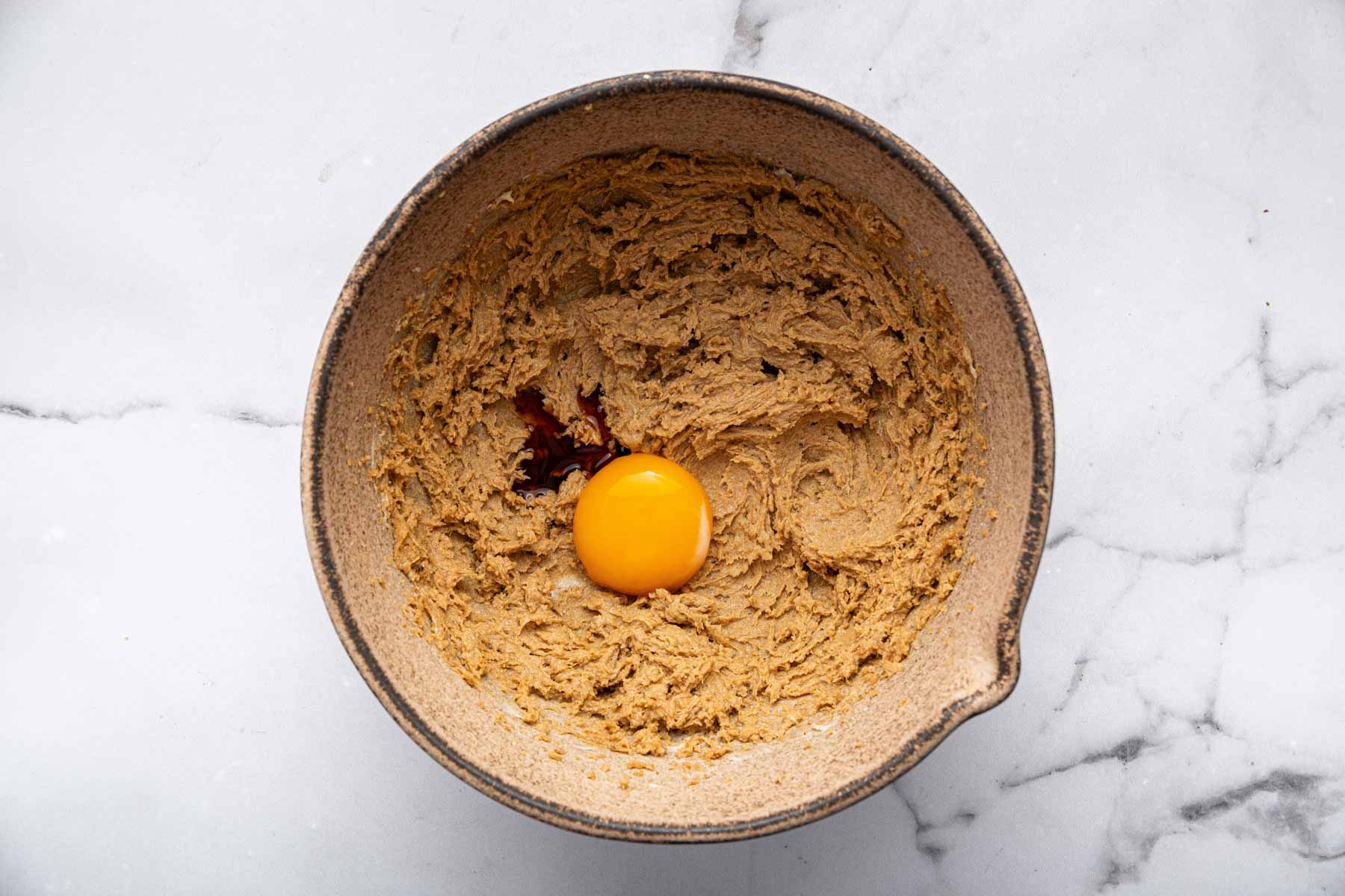 Single egg yolk in bowl with dessert batter.