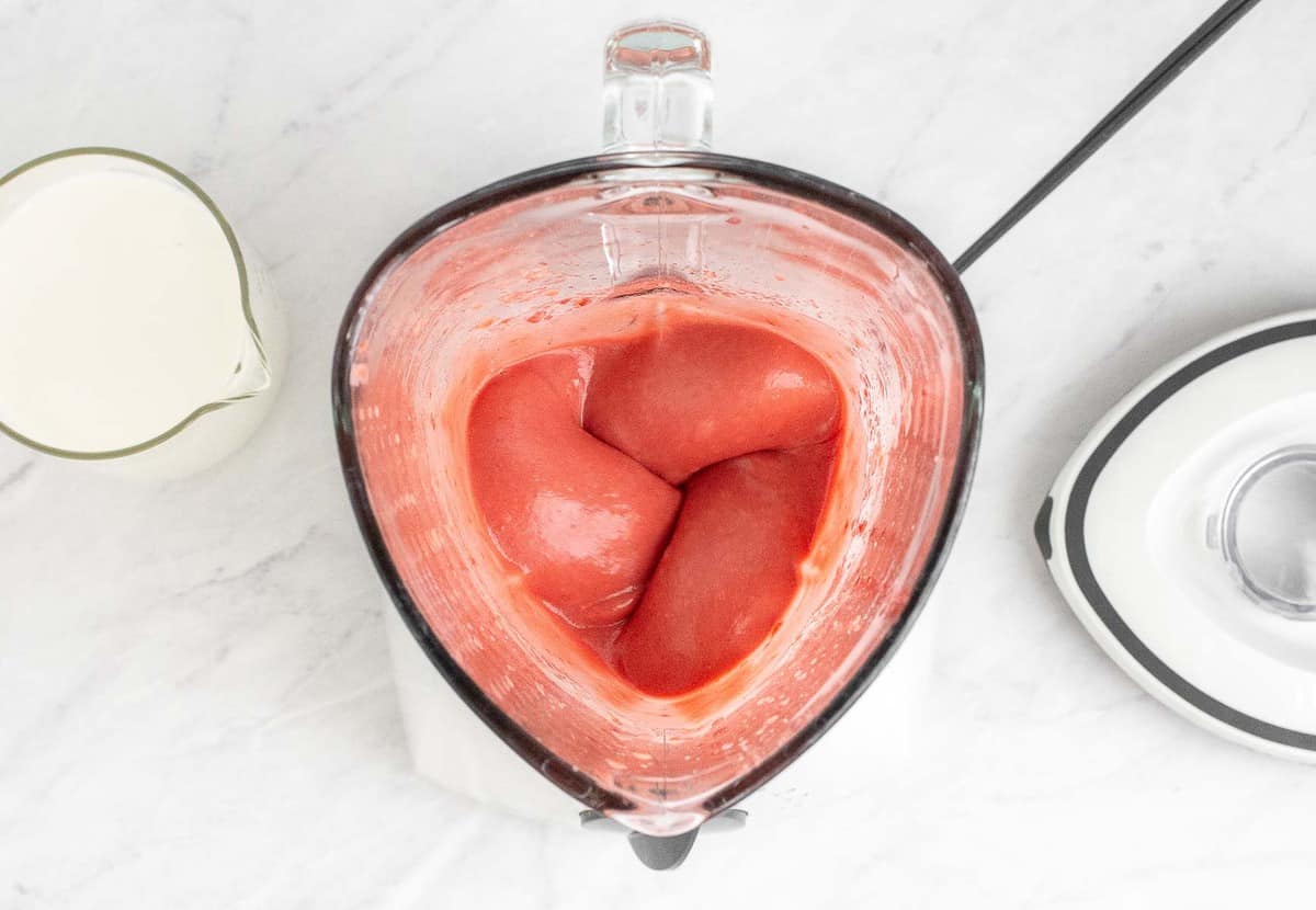 Strawberries pureed in a blender.