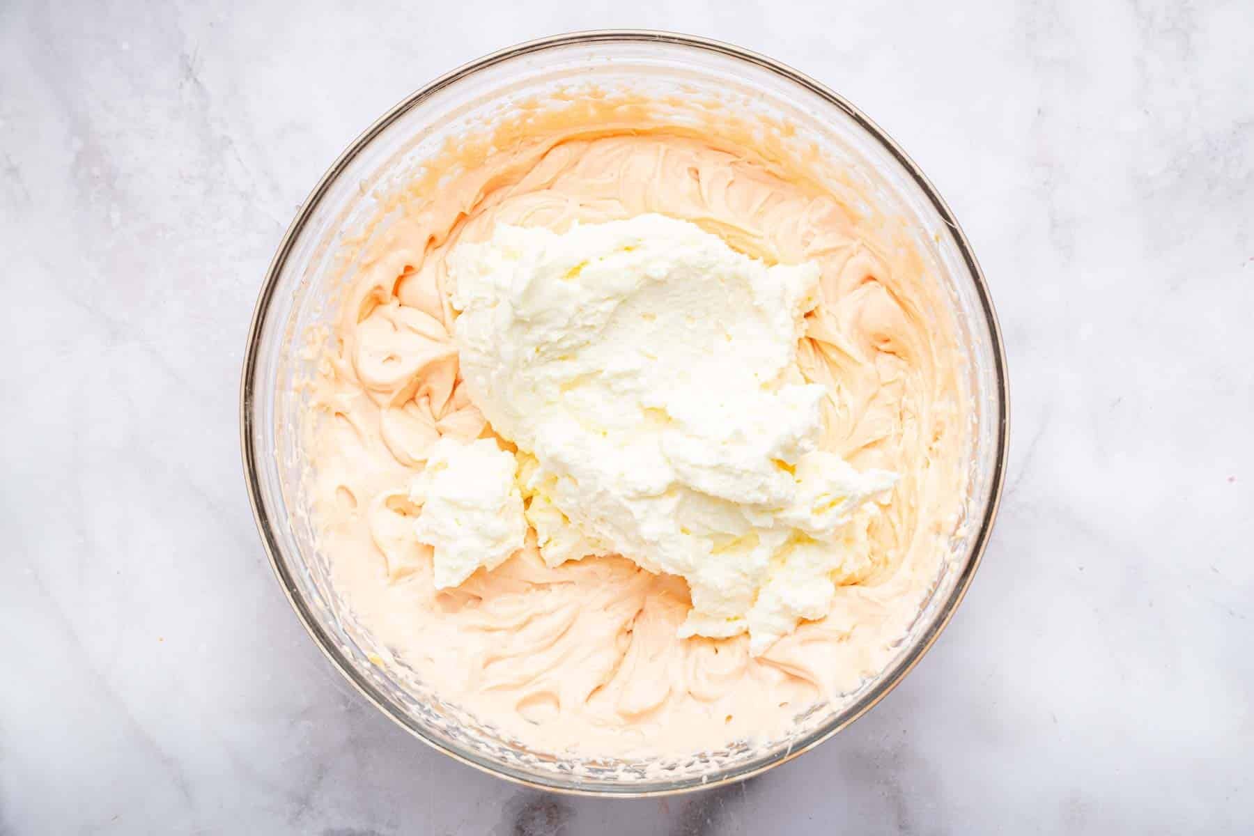 Bowl with beaten mascarpone and whipped cream piled on top.