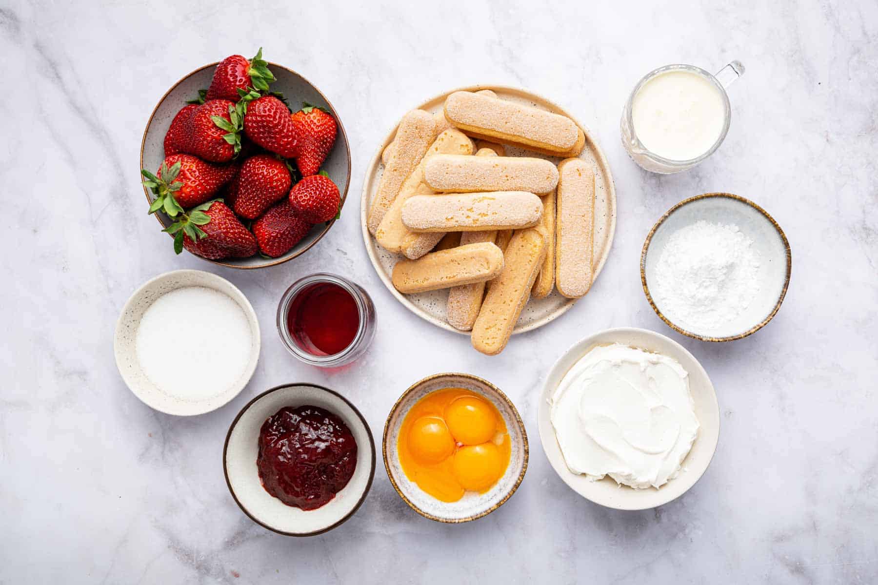 Little bowls with egg yolks, fresh fruit, lady fingers, and jam.
