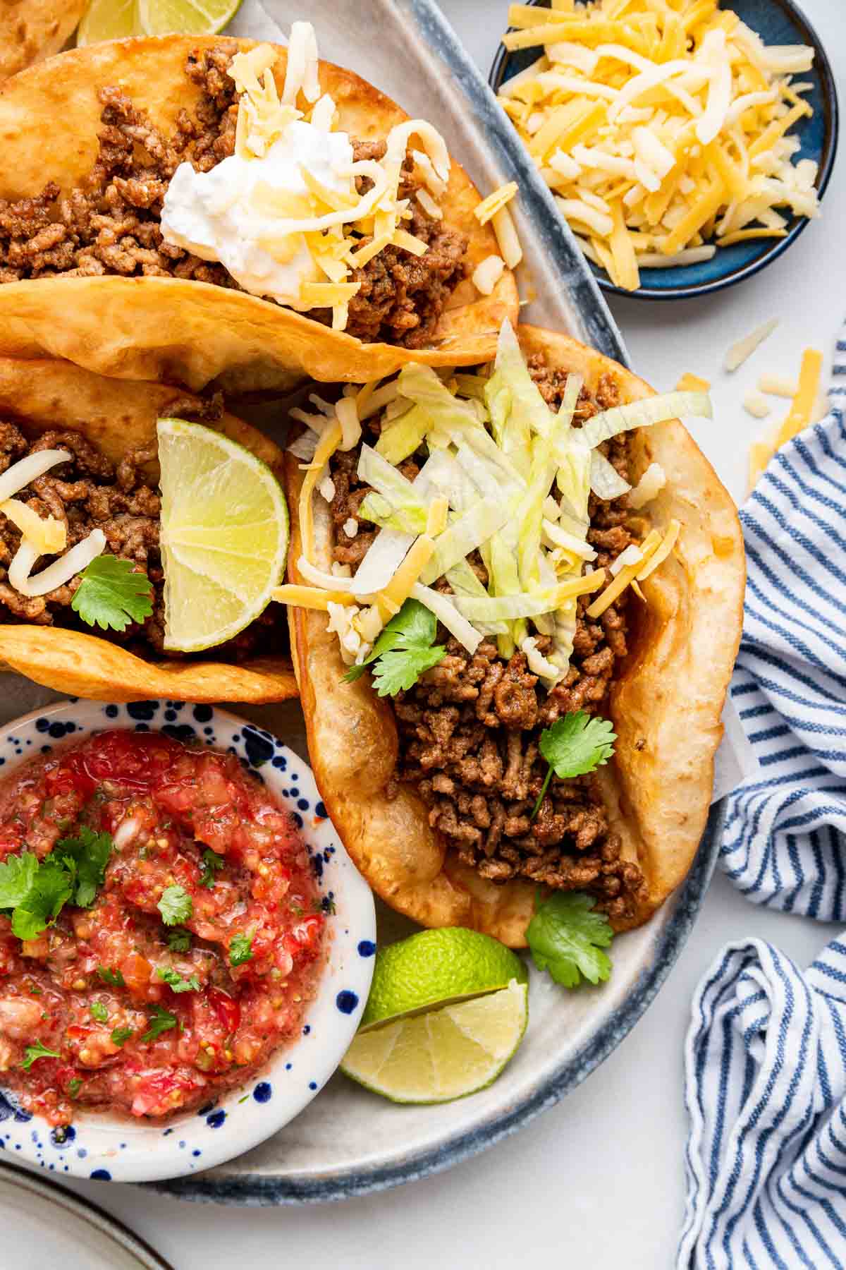 Tacos with ground beef and shredded cheese on top.